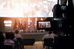 Kamerabildschirm zeigt Podiumsdiskussion 