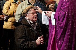 Das Aschekreuz wird entweder direkt auf die Stirn gezeichnet oder über die Haare des Gläubigen gestreut.