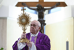 Papst Franziskus mit einer Monstranz in den Händen.