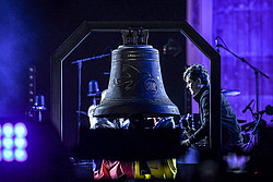 Glocke aus Bronze und Kriegsschrott bei der Kundgebung und dem Friedenskonzert Sound Of Peace gegen den Krieg in der Ukraine am Brandenburger Tor Berlin, im Hintergrund Michael Patrick Kelly