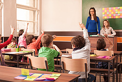 Klassenzimmer mit SchülerInnen und einer Lehrerin 