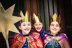 Drei Mädchen als Sternsinger verkleidet mit Stern