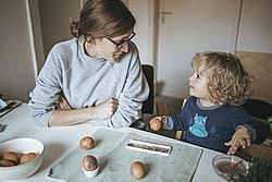 Frau und Kinder beim Ostereier bemalen