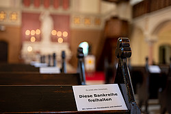 Ein Schild "Die Bankreihe freihalten" in einer Kirche