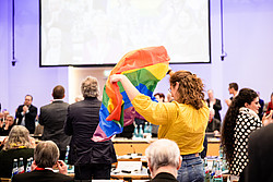 Synodale hält Regenbogenfahne hoch